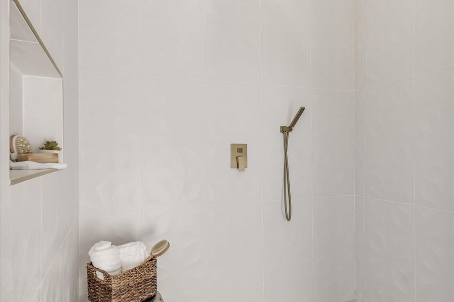 A sleek, fully tiled shower offers a modern, serene bathing space.
