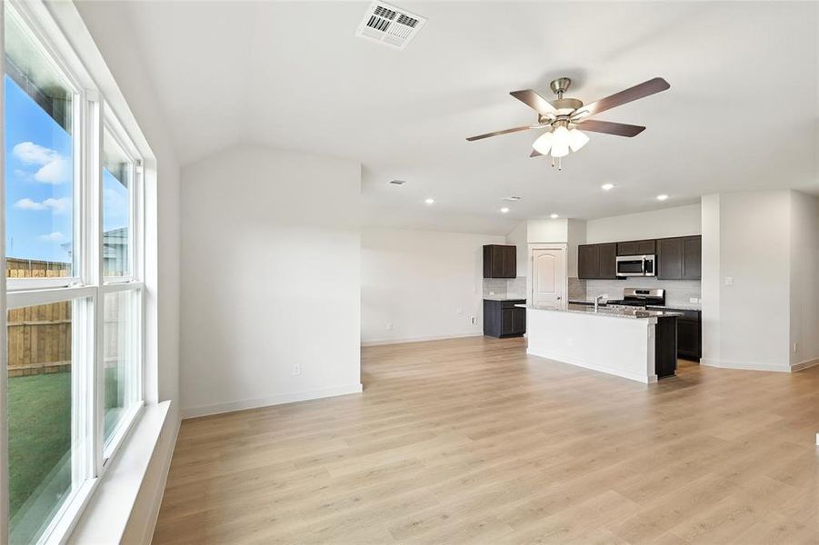 Unfurnished living room featuring ceiling fan, light wood-type flooring, and recessed lighting Unfurnished living room featuring ceiling fan, light wood-type flooring, and recessed lighting