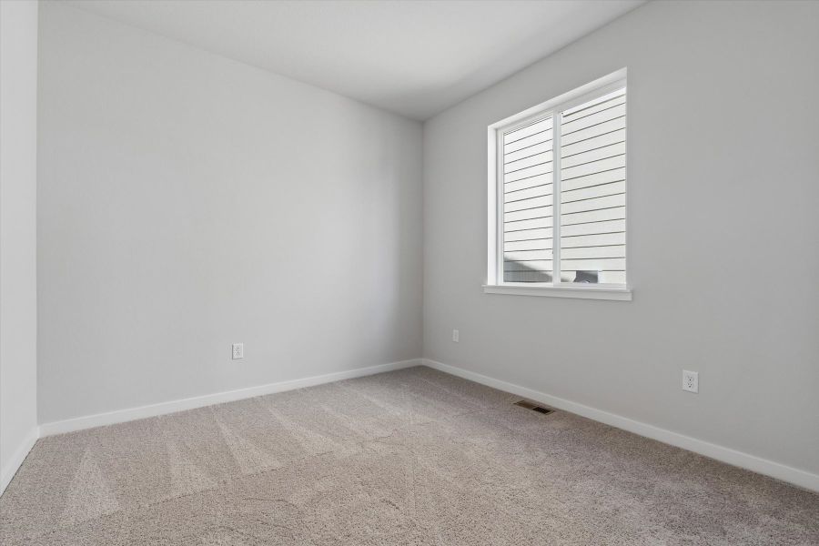 A room with a window and carpet.