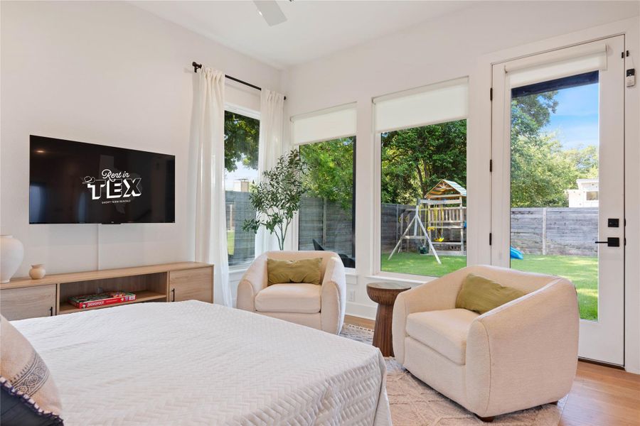 Floor-to-ceiling glass doors open directly to the yard, framing serene outdoor views.