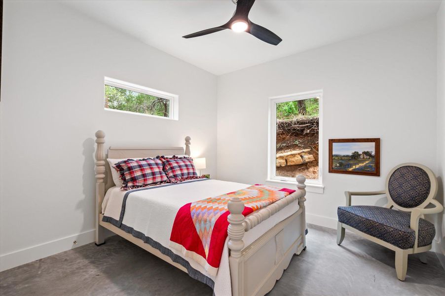 Secondary bedroom with a large light bright window surrounded by an earthy feel.