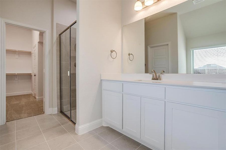 Bathroom with tile patterned flooring, vanity, and walk in shower