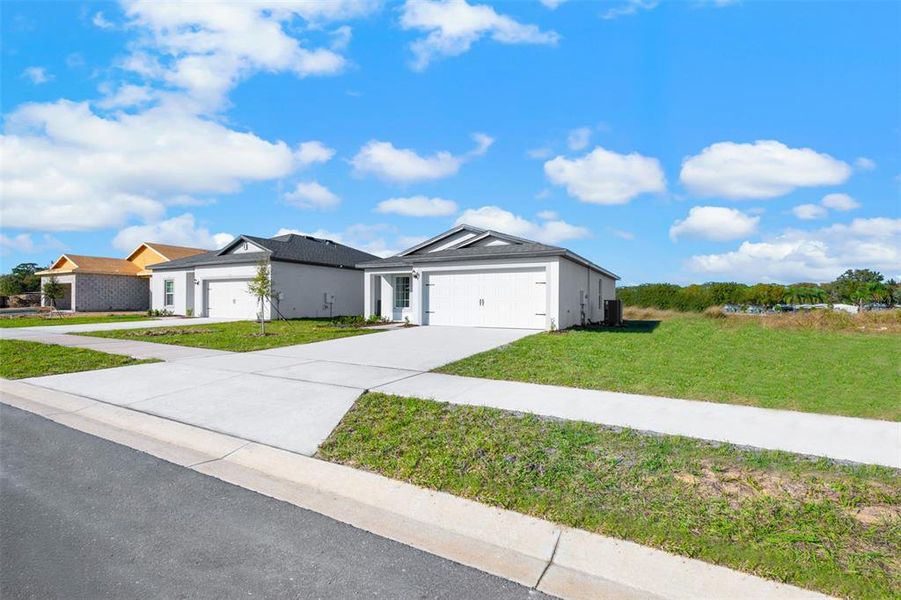 Front exterior of a new home in Tula Parc, Astatula, FL, highlighting curb appeal (Image 17). Front exterior of a new home in Tula Parc, Astatula, FL, highlighting curb appeal (Image 17).