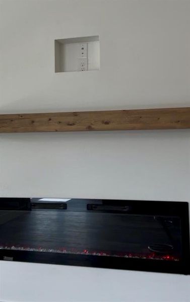 Built-in linear fireplace with a distressed wood mantel