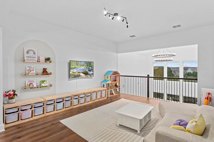 Living room featuring hardwood / wood-style flooring, rail lighting, and a chandelier