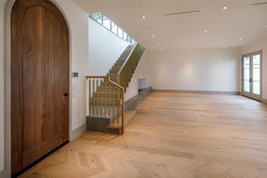 Step inside something completely new. White oak floors, an arched wood entry door, brass stair detailing, and walls waiting for their first collection of art introduce a home that has just received its finishing touches.
