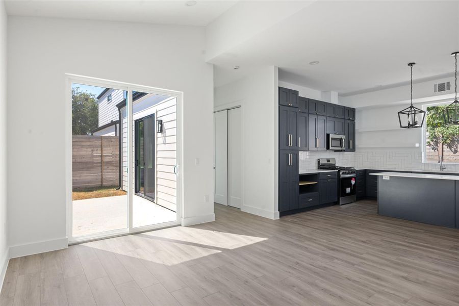 Kitchen with decorative light fixtures, appliances with stainless steel finishes, plenty of natural light, light wood-style flooring, and recessed lighting Kitchen with decorative light fixtures, appliances with stainless steel finishes, plenty of natural light, light wood-style flooring, and recessed lighting