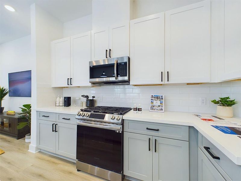 This attractive kitchen is full of beautiful details. Quartz countertops, stainless steel sink, stainless steel appliances, recessed lighting, undercabinet lighting, pantry, elegant cabinetry with soft close drawers and doors. Photos from another development by Disama Building Group. FINISHES & COLORS MAY VARY.