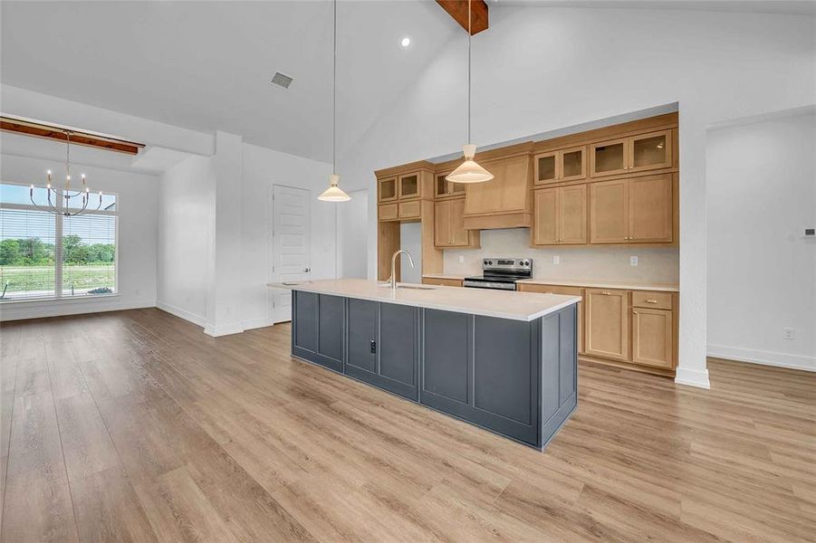 Kitchen featuring baseboards, electric stove, light wood finished floors, and light countertops Kitchen featuring baseboards, electric stove, light wood finished floors, and light countertops