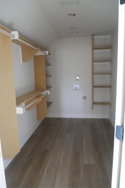 Spacious walk-in closet with custom shelving for optimal storage and functionality. Spacious walk-in closet with custom shelving for optimal storage and functionality.