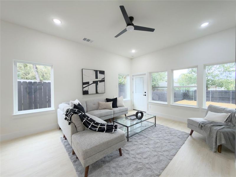 Living area featuring plenty of natural light, light wood-type flooring, recessed lighting, and ceiling fan