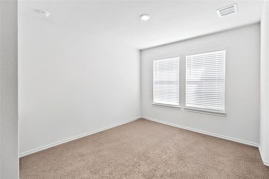 Carpeted spare room featuring baseboards and a smoke detector