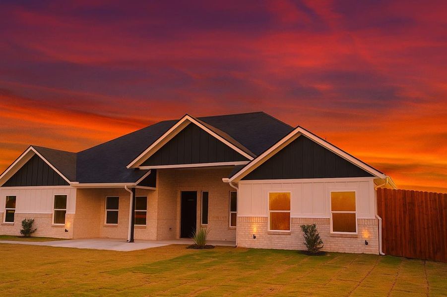 View of front of home with board and batten siding and brick siding(rendering of sky)