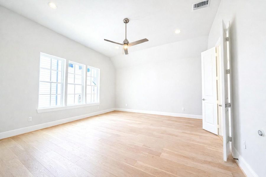 LARGE 15x18 primary bedroom with wood floors.