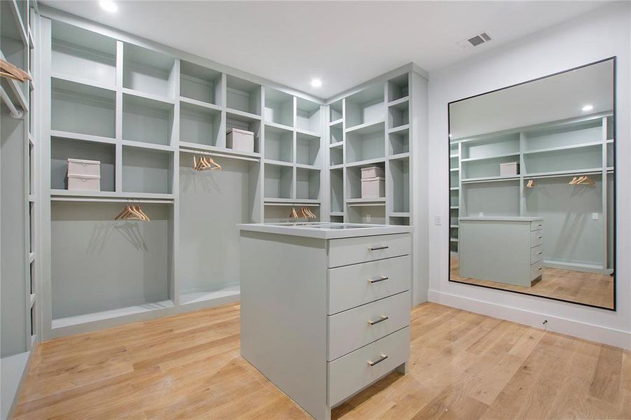 Walk in closet with light wood-style floors Walk in closet with light wood-style floors