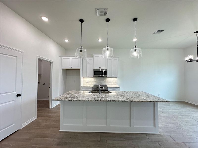 Modern kitchen island featuring a light-toned stone countertop and white paneling