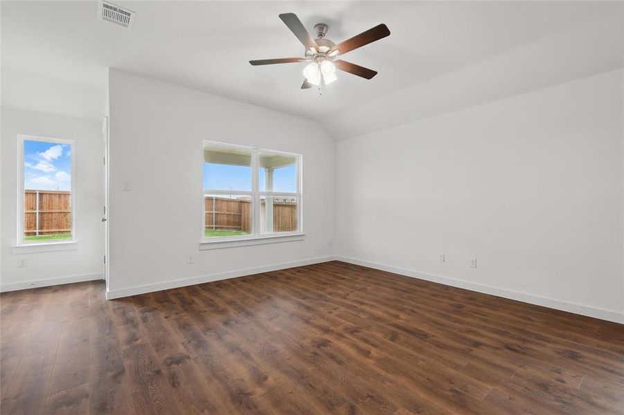 Empty room featuring dark wood-type flooring, lofted ceiling, and ceiling fan Empty room featuring dark wood-type flooring, lofted ceiling, and ceiling fan