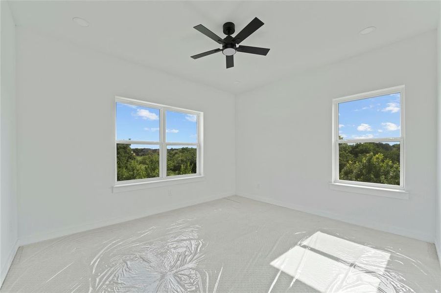 Unfurnished room featuring light carpet and ceiling fan Unfurnished room featuring light carpet and ceiling fan