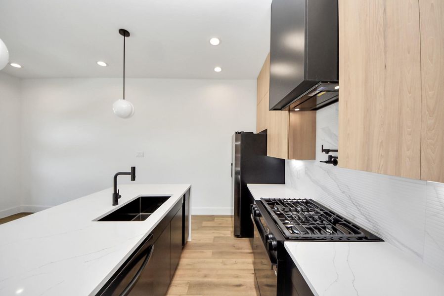 This beautiful modern kitchen includes a gas range with a pot filler faucet. Fridge is also included.
