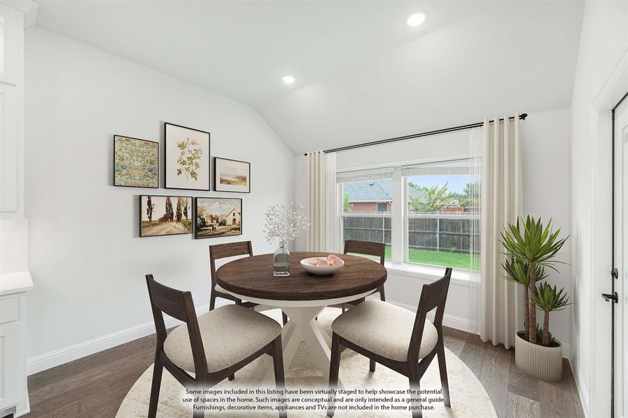 Dining area with round wood table, four chairs, vaulted ceiling, and large window overlooking backyard Dining area with round wood table, four chairs, vaulted ceiling, and large window overlooking backyard
