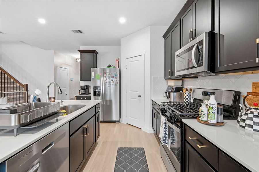From this angle, the kitchen flows effortlessly into the entry hallway, highlighted by a spacious island, elegant dark cabinetry, and a thoughtfully designed, cohesive layout. From this angle, the kitchen flows effortlessly into the entry hallway, highlighted by a spacious island, elegant dark cabinetry, and a thoughtfully designed, cohesive layout.