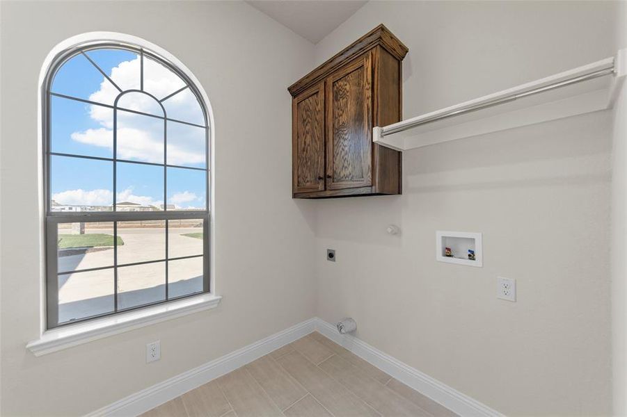 Washroom featuring hookup for a gas dryer, hookup for a washing machine, cabinets, and hookup for an electric dryer