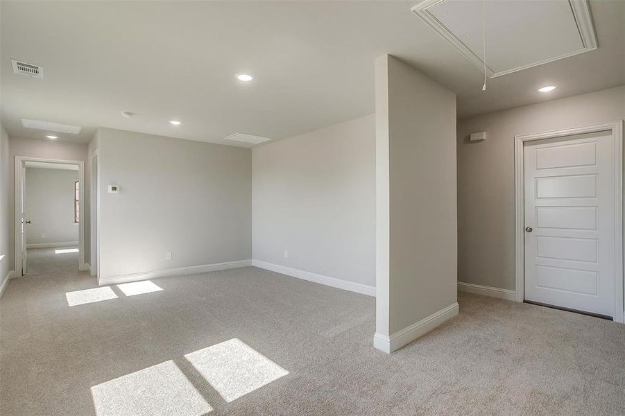 Carpeted empty room with attic access and recessed lighting Carpeted empty room with attic access and recessed lighting