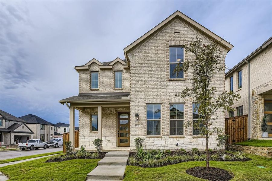 View of front of house featuring covered porch, brick siding, a front lawn, and stone siding View of front of house featuring covered porch, brick siding, a front lawn, and stone siding