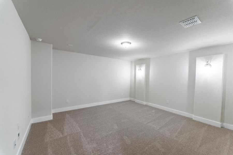 Carpeted spare room with baseboards and a textured ceiling