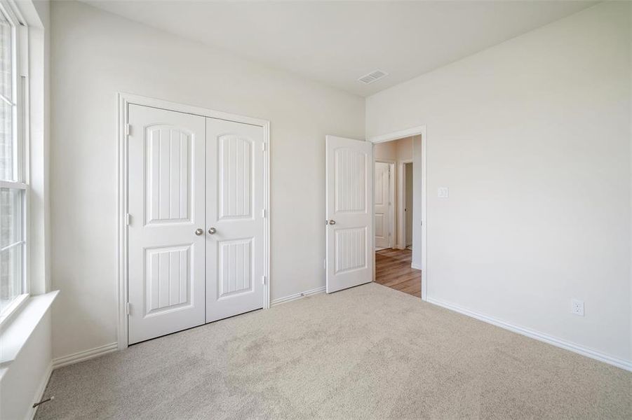 Unfurnished bedroom featuring carpet and a closet