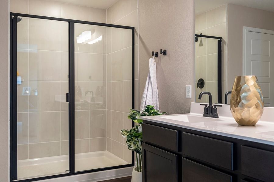 Walk-in shower with tile surround and matte black enclosure at primary bath Walk-in shower with tile surround and matte black enclosure at primary bath