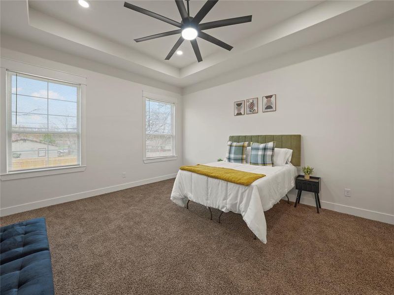 Bedroom featuring dark carpet, recessed lighting, ceiling fan, and a raised ceiling