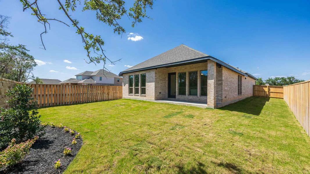 Back of house featuring brick siding, a fenced backyard, and a shingled roof Back of house featuring brick siding, a fenced backyard, and a shingled roof