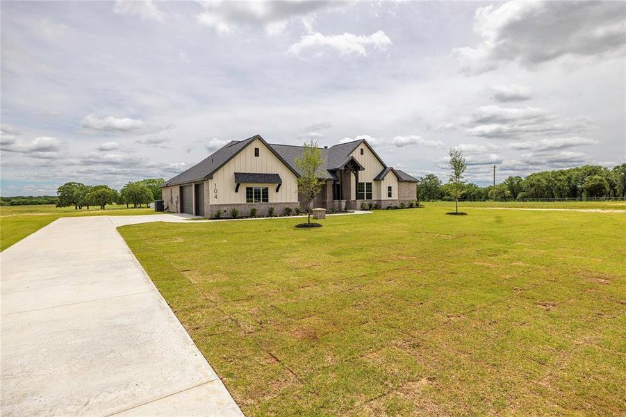 Front exterior of a new home in Prairie Winds Estates, Poolville, TX, highlighting curb appeal (Image 24).