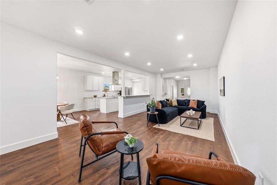 Open-concept interior featuring wood-finish flooring, recessed lighting, white walls, and substantial baseboards