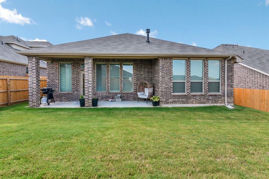 Rear view of house featuring a fenced backyard, a patio, brick siding, and a shingled roof