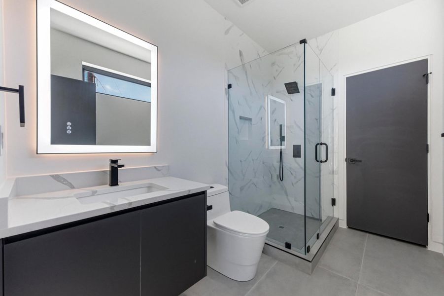 Full bathroom featuring vanity and a marble finish shower