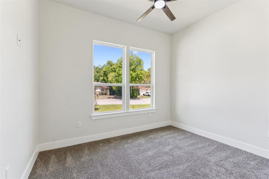 Carpeted spare room with ceiling fan