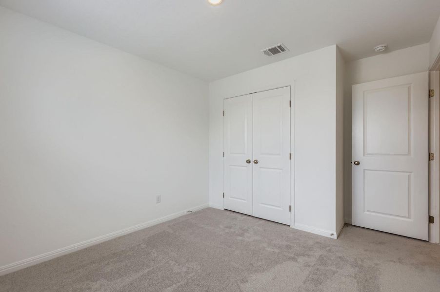 Unfurnished bedroom with carpet flooring and a closet Unfurnished bedroom with carpet flooring and a closet