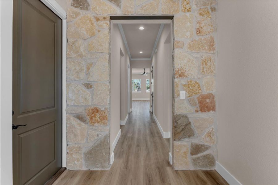Hall with ornamental molding, light wood-style flooring, and recessed lighting