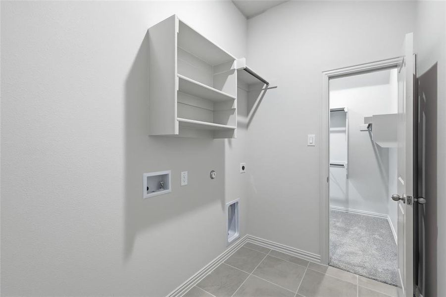 Laundry area featuring hookup for an electric dryer, washer hookup, hookup for a gas dryer, and light tile patterned floors