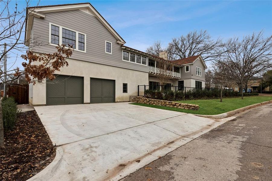 View of front facade featuring an attached garage, fence, driveway, stucco siding, and a front lawn