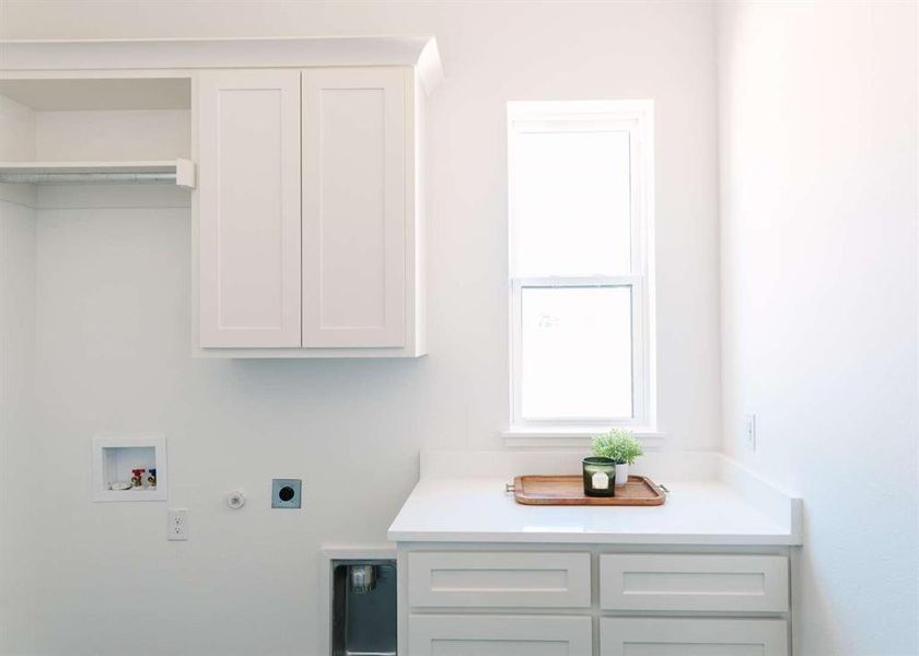 Washroom with hookup for a washing machine, hookup for a gas dryer, electric dryer hookup, and cabinets