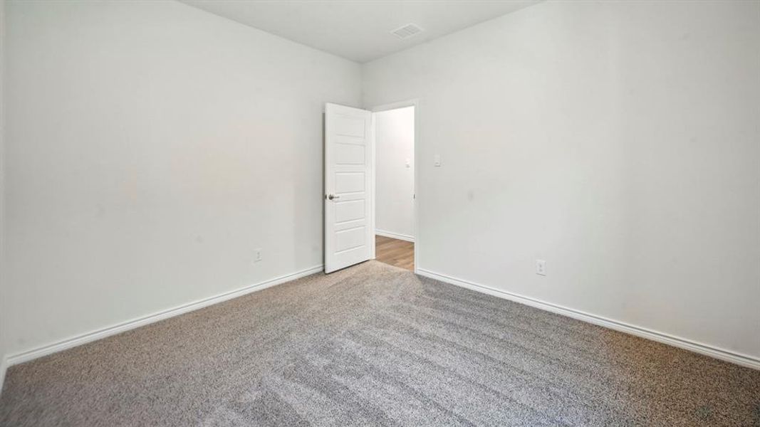 Spacious room featuring light gray carpeting, white walls, and white trim Spacious room featuring light gray carpeting, white walls, and white trim