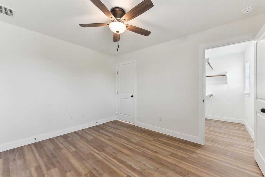 Unfurnished bedroom with light wood style floors, visible vents, a ceiling fan, a closet, and baseboards