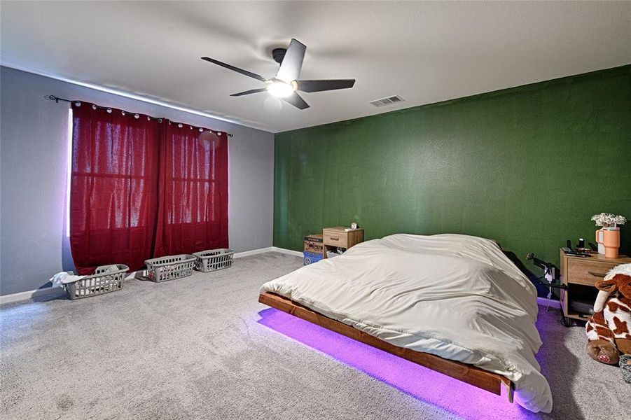 Carpeted bedroom with ceiling fan and baseboards Carpeted bedroom with ceiling fan and baseboards