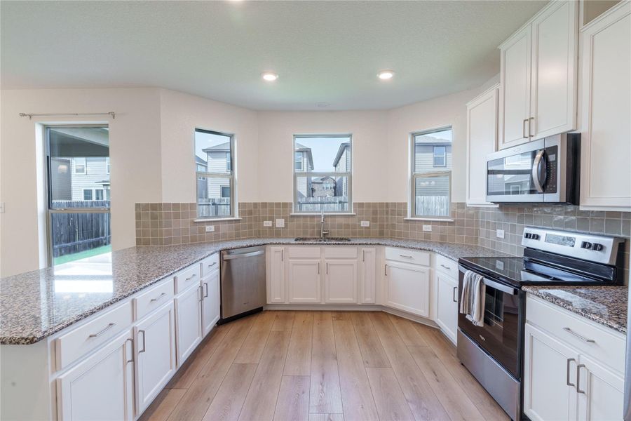 A well-appointed kitchen features ample counter space, bright cabinetry, and modern stainless-steel appliances. A well-appointed kitchen features ample counter space, bright cabinetry, and modern stainless-steel appliances.
