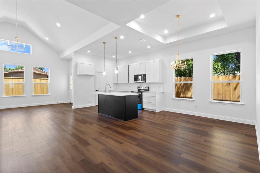 Kitchen featuring a chandelier, dark wood-style flooring, light countertops, open floor plan, and recessed lighting Kitchen featuring a chandelier, dark wood-style flooring, light countertops, open floor plan, and recessed lighting
