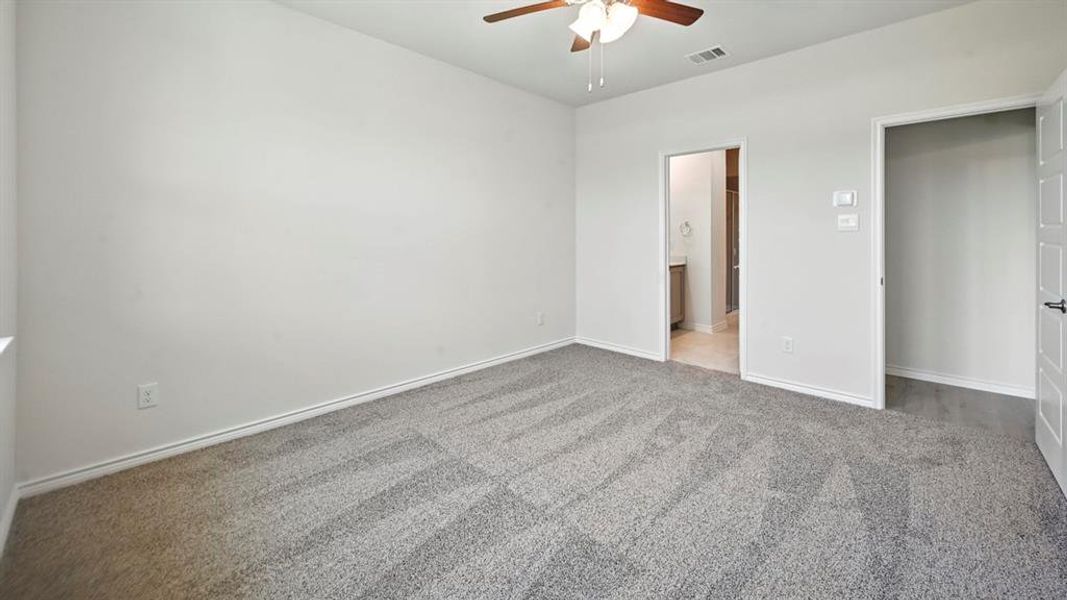 Unfurnished bedroom with light colored carpet, ceiling fan, and ensuite bath