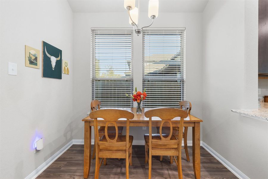 Bright dining area with large windows and modern light fixture.